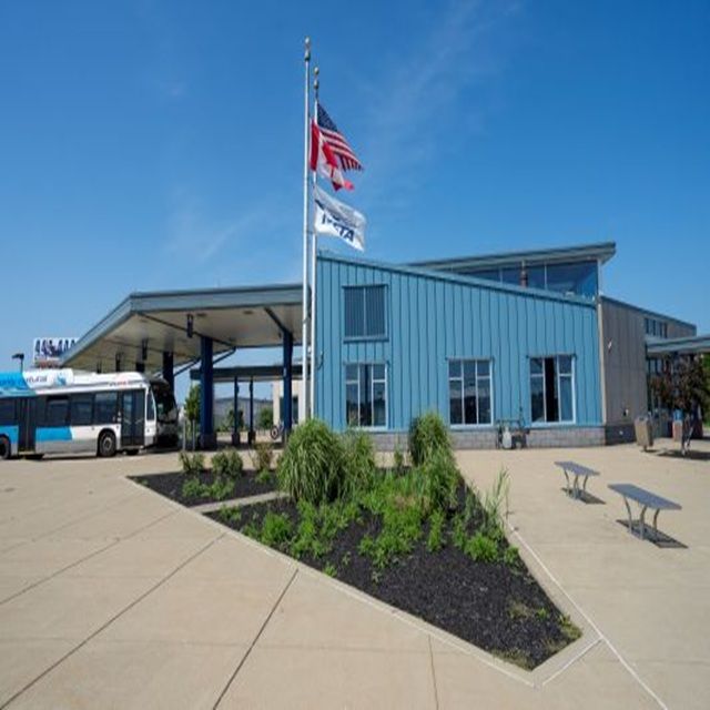 Exterior view of Niagara Falls Transportation center showing a bus to the left and landscaping.